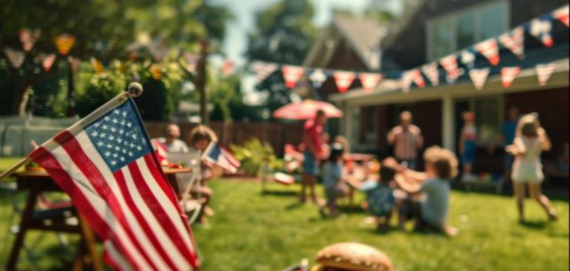 Family celebrating the Fourth of July at an outdoor cookout with American flags